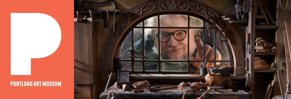 PAM logo and Guillermo del Toro looking through the window of a Pinocchio prop.
